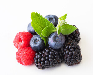 Various berries isolated on white background. Raspberry, Blueberry, Cranberry, Blackberry and Mint leaves