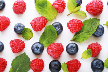 pattern of fresh blueberries and raspberries on a white background