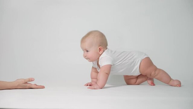 Baby 6 months old learning to crawl with parental help, the concept of child development and health