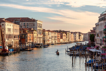 Fototapeta na wymiar Venezia, Rialto. Veduta del Canal Grande con gondola e Palazzi al tramonto.