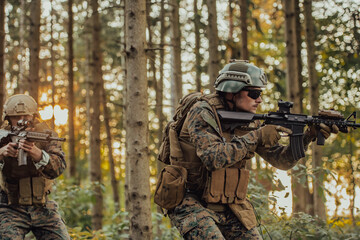 Fototapeta premium A group of modern warfare soldiers is fighting a war in dangerous remote forest areas. A group of soldiers is fighting on the enemy line with modern weapons. The concept of warfare and military