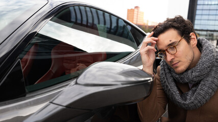 Man looking at himself in the car's rear view mirror to fix his hair