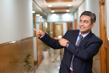 Indian businessman showing direction at office.