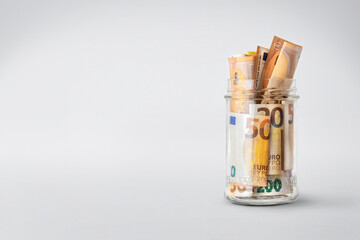 Euro bills in glass jar on white background with copy space. Saving money concept - Powered by Adobe