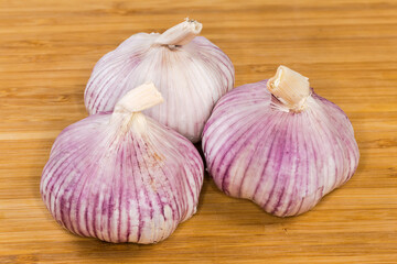Bulbs of the purple stripe garlic on a wooden surface