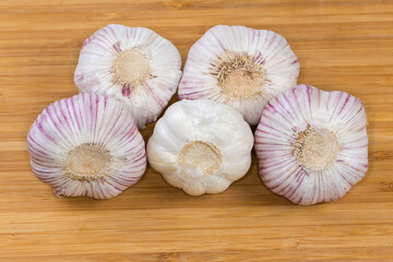 Bulbs of the garlic different varieties on a wooden surface
