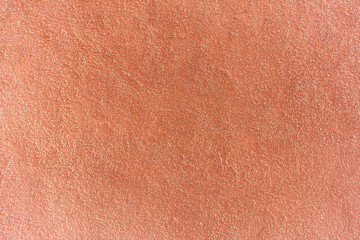 Close up of red painted plaster wall with rough surface