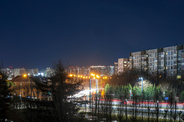 Fototapeta na wymiar Light trails against the backdrop of a nightly luminous city.