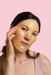 Woman uses a hydrogel mask on her face. Procedure at the cosmetologist. Face care and beauty treatments. Hydrogel face mask with collagen, hyaluronic acid for glowing skin.
