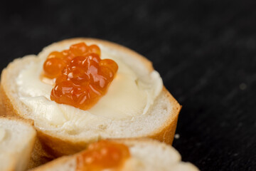 Thinly sliced baguette with salmon caviar and butter