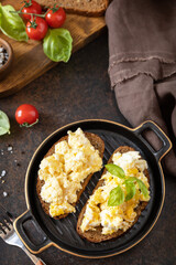 Scrambled eggs on whole grain bread. Homemade breakfast or brunch meal - scrambled eggs. Copy space.