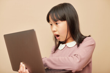 ノートパソコンで勉強している小学生の子供の様子