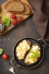 Scrambled eggs on whole grain bread. Homemade breakfast or brunch meal - scrambled eggs. View from above.