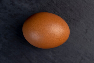 A whole orange chicken egg close-up on the table