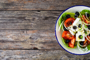 Fresh vegetable salad with feta cheese on wooden table

