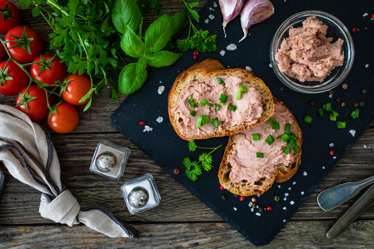 Tasty sandwiches with liverwurst and chive on wooden table
