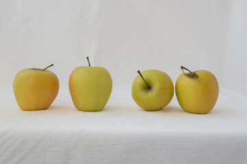 set of yellow apples, isolated, on a white cloth