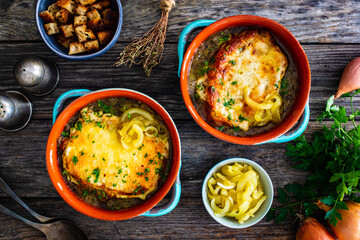 Onion soup with roasted bread with cheese on wooden table
