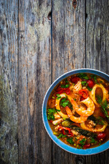 Seafood and fish soup on wooden table

