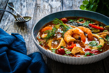 Seafood and fish soup on wooden table
