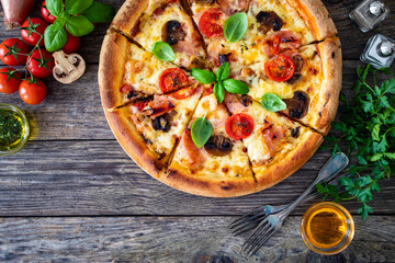 Circle pizza with boiled ham and  mushrooms on wooden table
