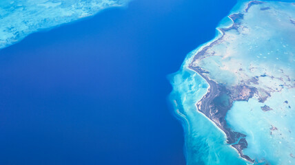 Aerial view from the plane flying across the Caribbean looking down on the Caribbean Sea and the beautiful islands of the tropics