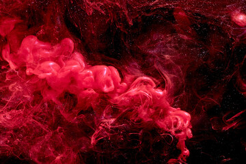Red abstract ocean background. Splashes and waves of paint under water, clouds of smoke in motion.