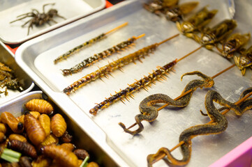 Exotic food in Khao San road at night in Bangkok city, Thailand, Holidays and traveling concept