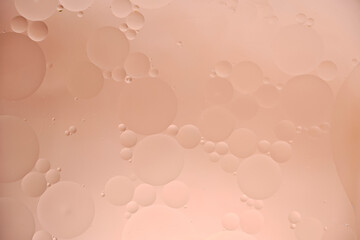 Beige abstract background with oil circles, streaks and gradient.
