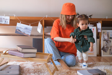 happy and love family, child and motherhood concept happy mother with little baby girl and developmental toys in living room at home.