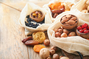 Tu Bishvat celebration concept. Mix of dry fruits and nuts almonds, hazelnuts, walnuts, apricots, prunes, cherries, raisins, dates, apples, figs over wooden table. Jewish holiday, new year of trees.