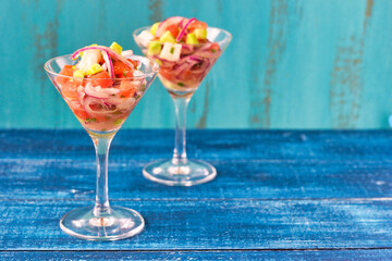 青背景のメキシコのシーフードのセビーチェ　コピースペースあり　スタイリッシュな雰囲気で Mexican Seafood Ceviche (Cebiche) blue background with copy space in a stylish atmosphere