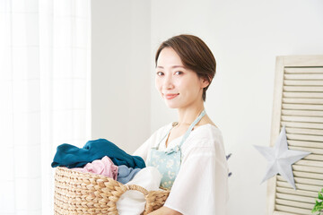 洗濯物を運ぶ主婦　カメラ目線
