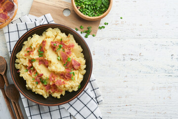 Mashed potatoes. Bacon mashed potatoes with green onion, pepper and cheddar cheese in bowl on old wooden backgrounds. Delicious creamy mashed potatoes. Top view.