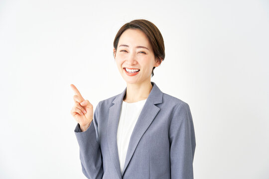 左側を指差すビジネスウーマン　白背景