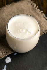 White cow's milk poured into a transparent glass on the table