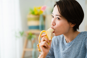 バナナを食べる若い女性　飲食イメージ