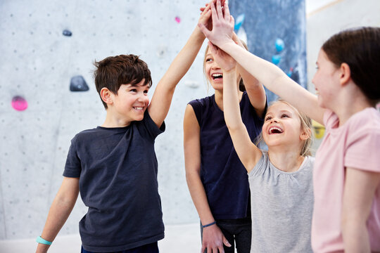 Little kids high fiving in a bouldering gym