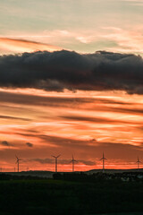 Wunderschöner Sonnenuntergang am Himmel mit goldenen Wolken und Windräder, Würburg, Franken, Bayern, Deutschland