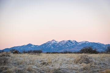Distant mountain range with hills covered in grass in the forground in Arizona.