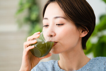 青汁を飲む若い女性　飲食イメージ