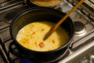 Cocción en cacerola de arroz con morrones rojos y verdes, risotto sobre cocina