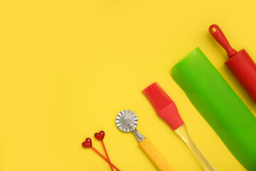 culinary accessories on a yellow background, rolling pin, brush, silicone mat, dough knife, skewers, culinary background