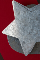close up of a galvanized sheet metal star cutout on a red brown background - macro lens, particular focus