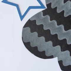 Fotobehang blue star shape detail and abstract black paper shape with decorative wavy line pattern on blank paper  © eugen