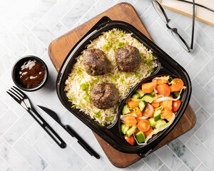 An appetizing dish of flavorful rice, 3 grilled meatballs, sautéed vegetables, and BBQ sauce. Perfect for food design and advertising, Top View