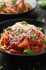 Italian marinara sauce spaghetti pasta served with fresh basil, olives and pecorino cheese