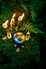 Minerals, amulet, symbol of moon and candles on dark natural forest background. Witchcraft,...