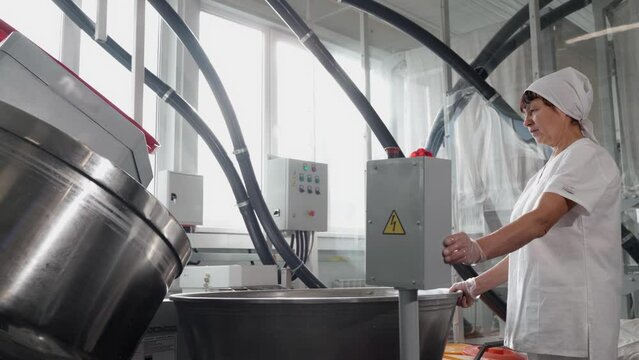 A woman baker works with a spiral kneader with a self-tilting function.