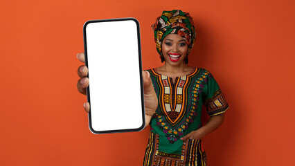 Happy traditional african woman holding huge smartphone, mockup